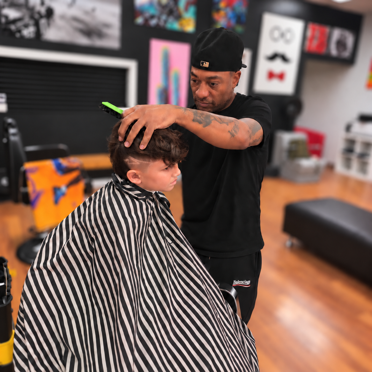 Jimmie giving a young client a precise haircut at Redds Barber Salon